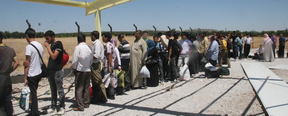 Menschen stehen Schlange an der türkisch-syrischen Grenze