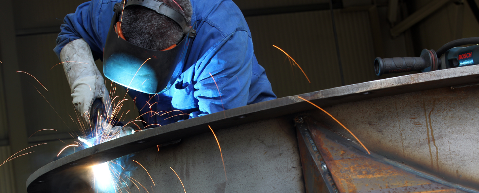 Ein Mann arbeitet mit einem Schweißgerät an einem Industriebehälter, aufgenommen am 05.08.2010 in Aue (Sachsen).
