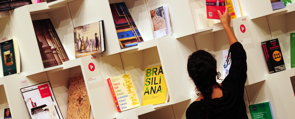 Eine Frau sortiert auf der Buchmesse in Frankfurt am Main am 08.10.2013 Bücher in einem Regal im Pavillon des Gastlandes Brasilien. Die weltweit größte Messe ihrer Art dauert noch bis zum 13. September.