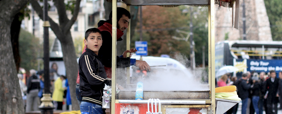 Zwei Jungen verkaufen am Sultanahmet-Platz gekochte Maiskolben.