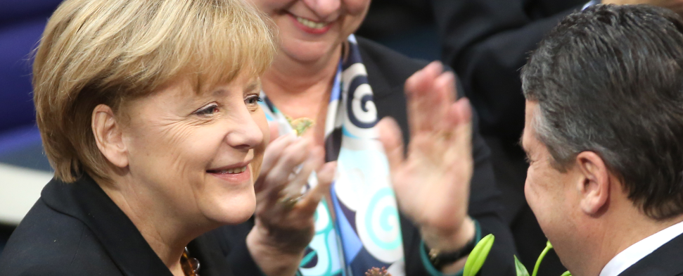 Bundeskanzlerin Angela Merkel (CDU - l) nimmt im Bundestag in Berlin am 17.12.2013 nach ihrer Wiederwahl die Gratulation und den Blumenstrauß von Vizekanzler Sigmar Gabriel (SPD - r) entgegen, während die Abgeordnete Gerda Hasselfeldt applaudiert - dpa