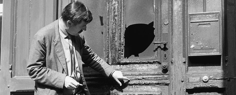 Der Schriftsteller Günter Grass steht am 16.09.1965 vor der angekohlten Tür seines Hauses in Berlin-Friedenau.