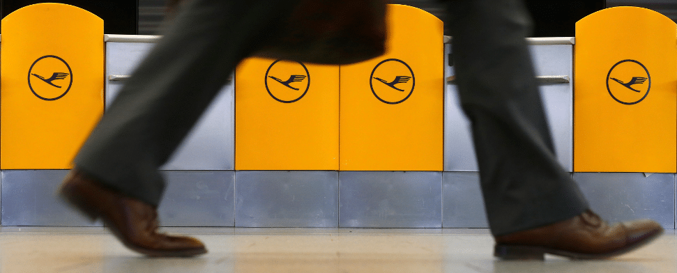 Ein Mann läuft an den Lufthansa-Symbolen vorbei.