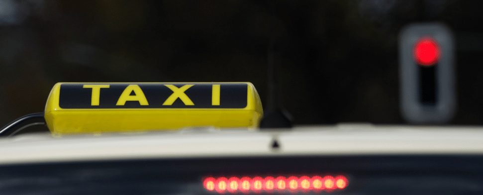Ein Taxi wartet in Berlin an einer roten Ampel.