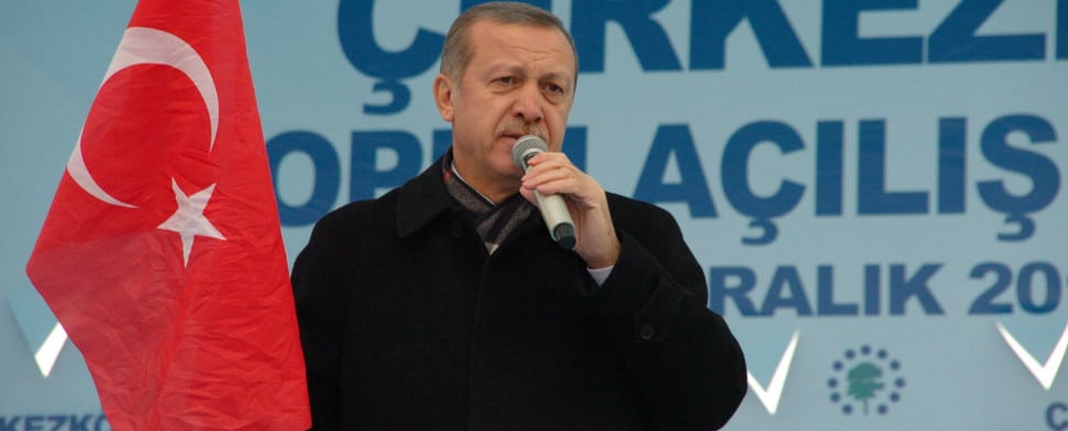 Der türkische Ministerpräsident hält eine türkische Nationalfahne in der Hand.