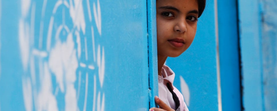 a palestinian refugee student peers from behind a united nations relief and works agency (unrwa) school door at ain al-hilweh refugee camp in southern lebanon, september 22, 2011.