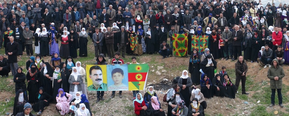 Familienangehörige des zwölf-jährigen Nihat Kazanhan stehen während seiner Beeredigung an einer Anhöhung. Sie halten das Bild des getöteten Jungen neben ein Poster von Abdullah Öcalan.