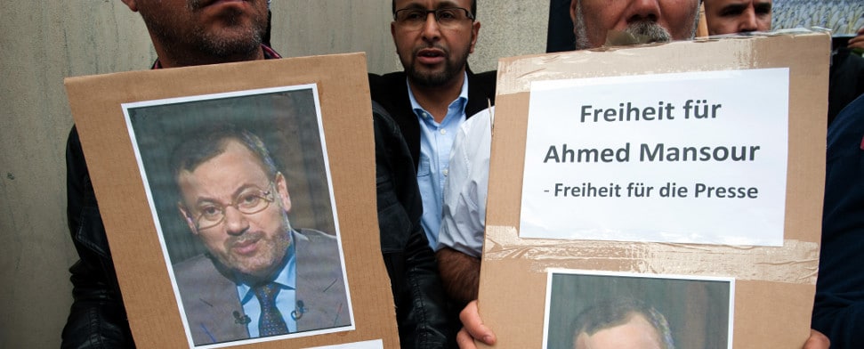 "Freiheit für Ahmed Mansour - Freiheit für die Presse" steht am 21.06.2015 in Berlin auf Plakaten vor einer Polizeistation. Dort demonstrierten schätzungsweise 60 Menschen für die Freilassung des Al Jazeera-Journalisten Ahmed Mansur. Der Journalist war am Samstag auf dem Flughafen Berlin-Tegel festgenommen worden, als er nach Doha in Katar fliegen wollte. Laut Bundespolizei lag ein internationaler Haftbefehl gegen ihn vor, der vom Bundeskriminalamt ins System eingestellt worden sei. Mansur gehört zu den bekanntesten TV-Journalisten der arabischen Welt. Ein Strafgericht in Kairo hatte ihn 2014 in Abwesenheit zu 15 Jahren Haft verurteilt, weil er im Frühjahr 2011 an der Folter eines Anwalts in Kairo beteiligt gewesen sein soll.