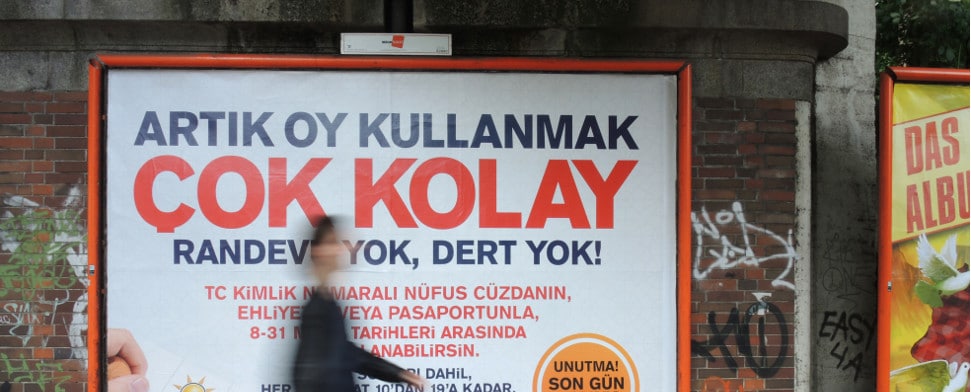 Ein Passant geht am 27.05.2015 in Berlin an einem Wahlplakat der türkischen Regierungspartei AKP vorbei. Die Türkei wählt am 7. Juni ein neues Parlament. Türkische Staatsbürger können auch in Deutschland ihre Stimme abgeben.