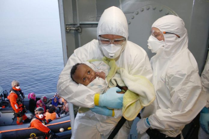 Marinesoldaten der Bundeswehr versorgen ein Baby, das von einem Fl+chtlingsboot gerettet wurde